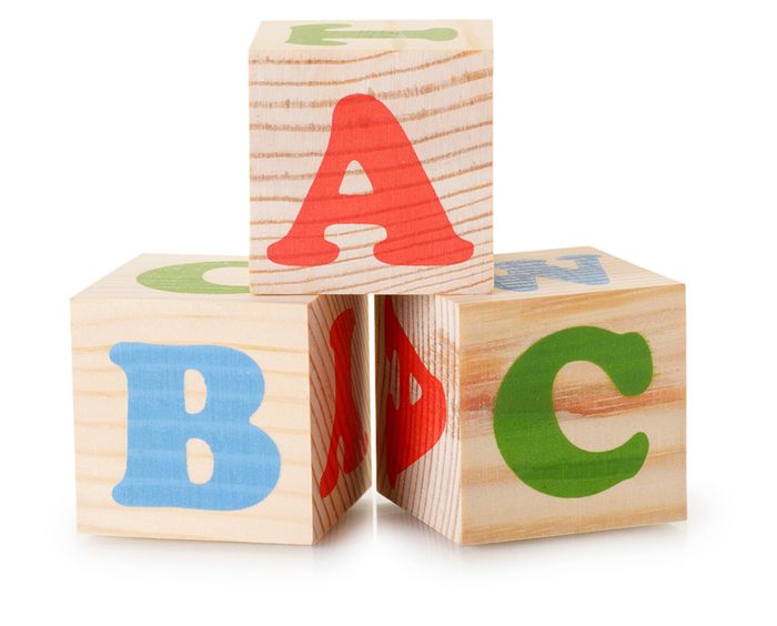 Drei Holzwürfel mit jeweilig den Buchstaben "A", "B" und "C" aufgetürmt in einer Pyramide